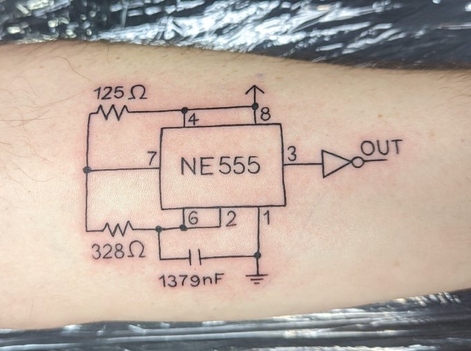 NE555 timer schematic tattoo, with resistor and capacitor values and an inverter connected to output pin 3.